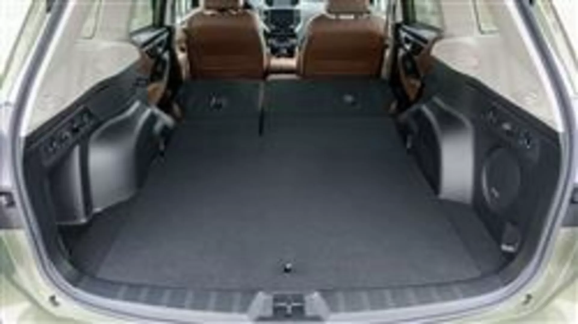 Spazio del bagagliaio del Subaru Forester 2015 con sedili posteriori abbattuti, che mostra l'area di carico vuota e il design interno di lusso in pelle marrone, vista da una prospettiva elevata