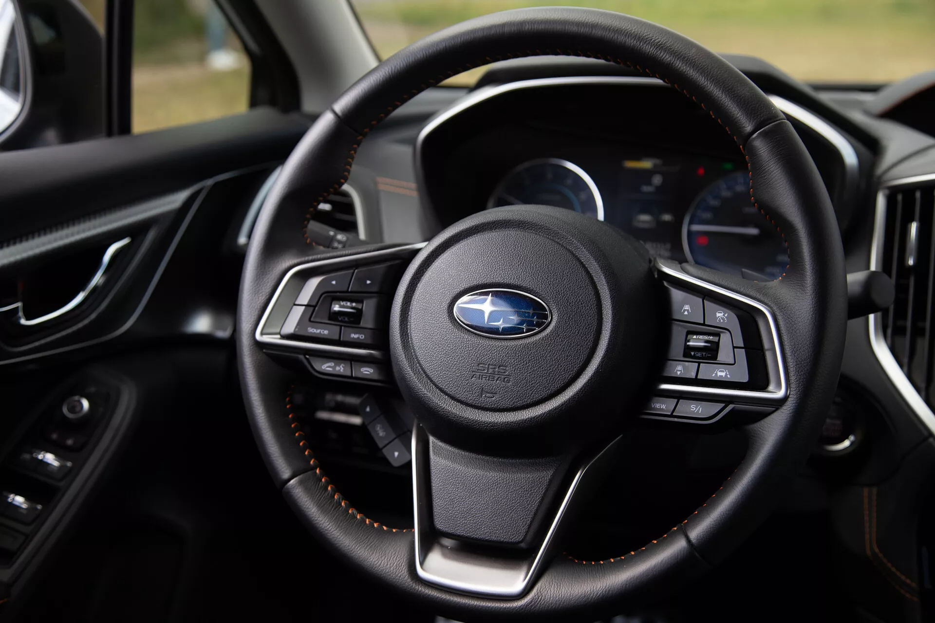 Vista ravvicinata del volante della Subaru XV 2021 con pulsanti multifunzione, rivestimento in pelle di lusso e cruscotto moderno con display digitali