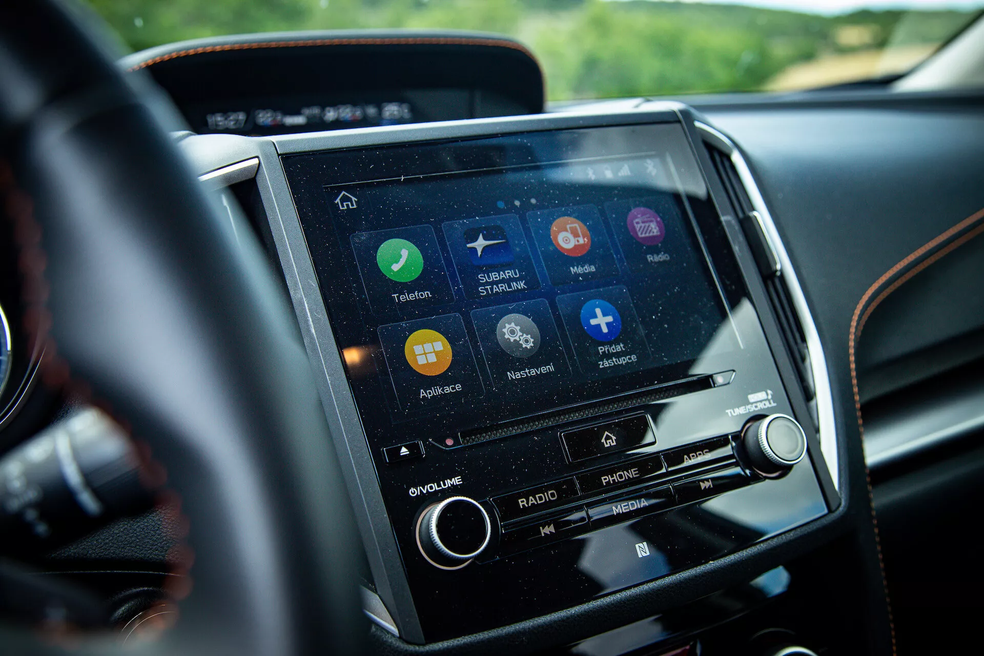 Vista ravvicinata del sistema touchscreen di infotainment della Subaru XV 2021 nella console centrale, dalla prospettiva del conducente, con applicazioni per navigazione, connettività telefonica e streaming musicale