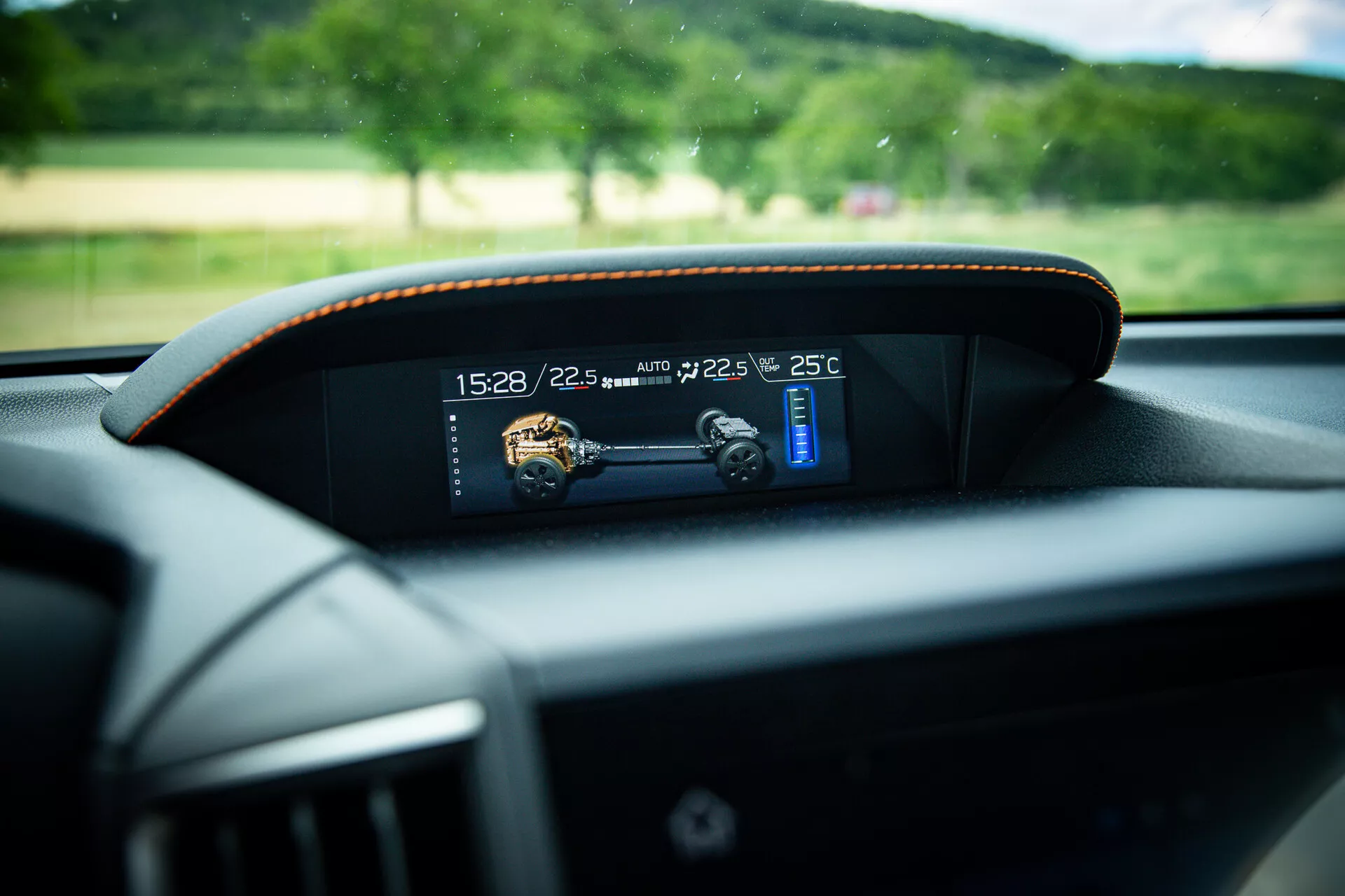 Vista ravvicinata del cruscotto digitale moderno in una Subaru XV 2021, che mostra indicatori di tempo, temperatura e velocità con cuciture a contrasto sottile intorno alla cornice, presa dalla prospettiva del sedile del conducente