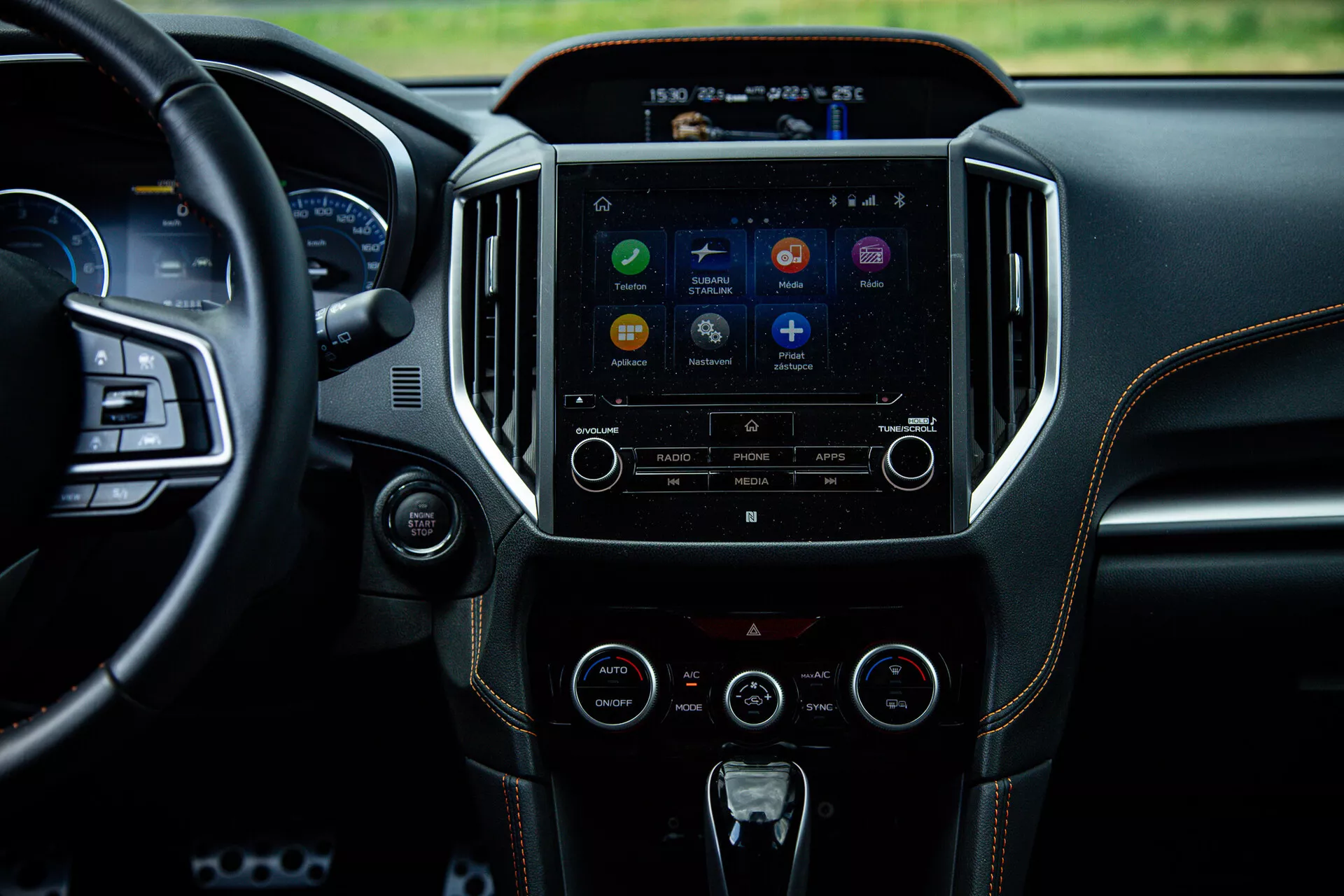 Interno della Subaru XV 2021 che evidenzia la consolle centrale e il sistema di infotainment da una prospettiva del sedile posteriore, mostrando il touchscreen con icone delle app, pulsanti per il controllo audio e clima, riflettendo tecnologia avanzata e design di lusso