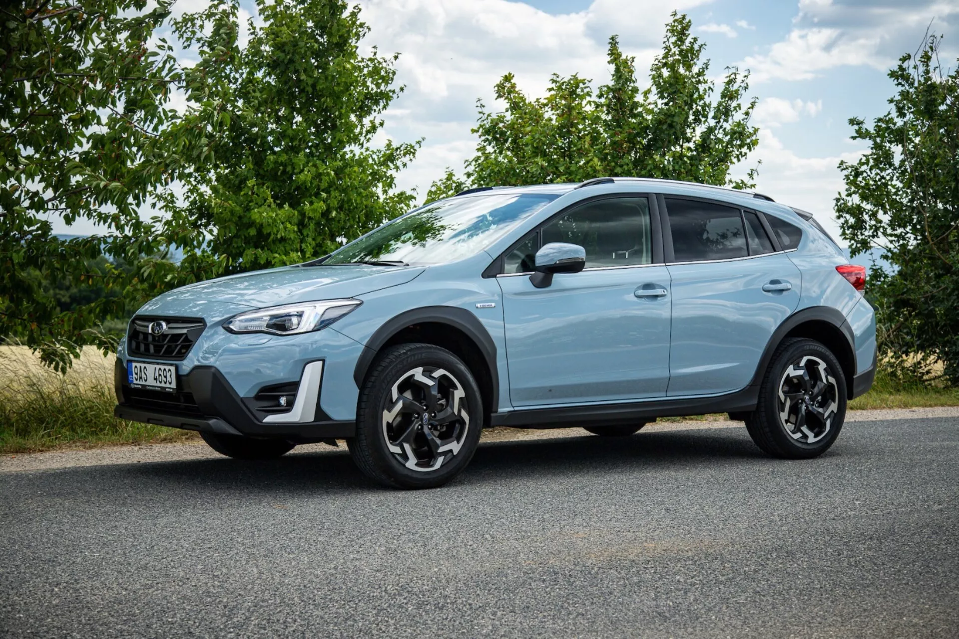 SUV crossover Subaru XV 2021 azzurro parcheggiato sull'asfalto mostrando profilo laterale, distintivi cerchi in lega neri, fanali posteriori LED, elevata altezza da terra per uso urbano e leggero fuoristrada, e caratteristiche di sicurezza moderne