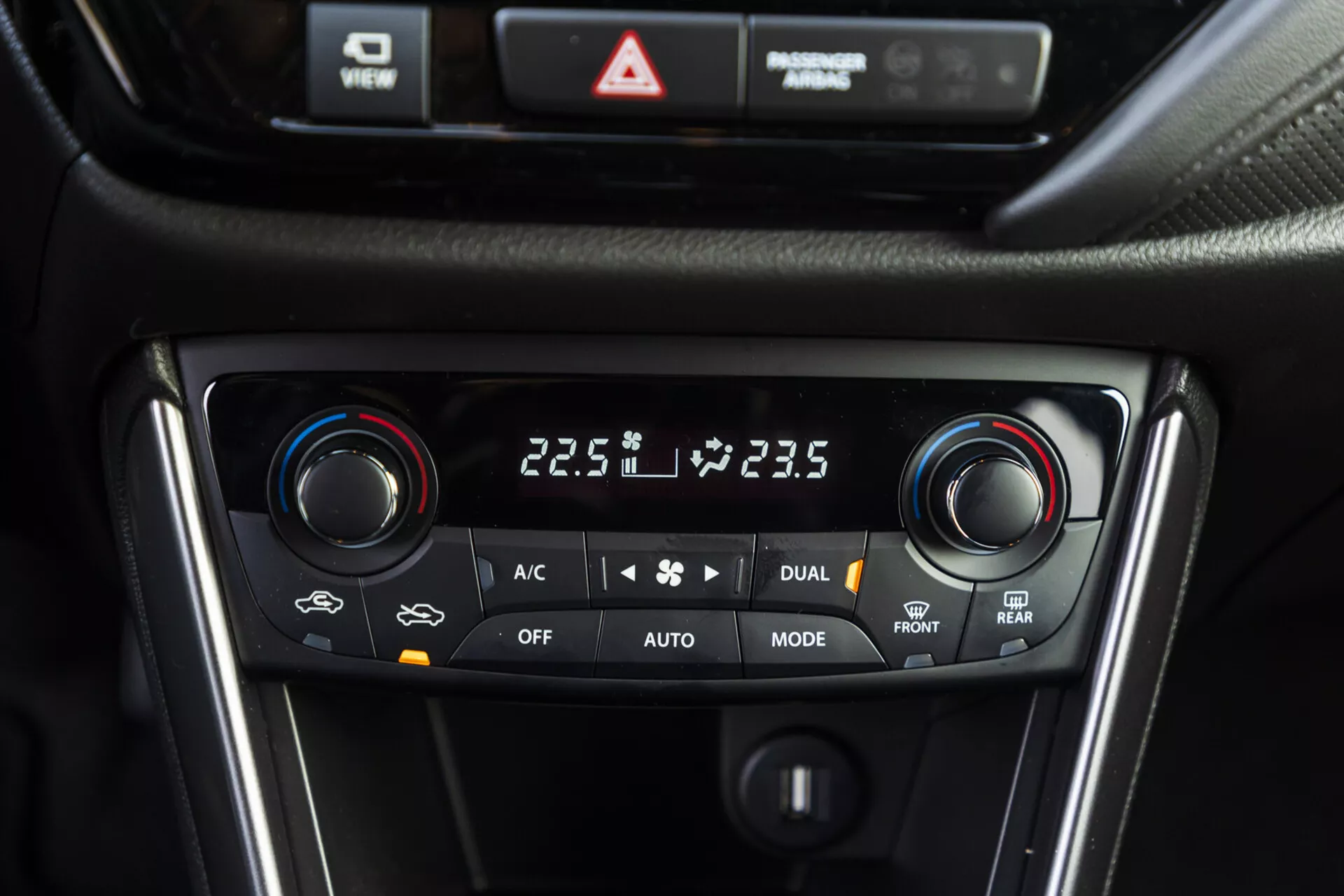 Vista ravvicinata del sistema di controllo climatico a doppia zona della Suzuki S-Cross 2022 che mostra le impostazioni della temperatura, le selezioni di modalità e le opzioni di sbrinamento