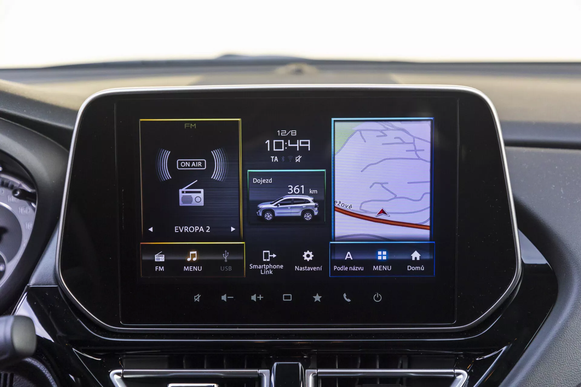 Cruscotto centrale della Suzuki S-Cross 2022 che mostra lo schermo del sistema di infotainment con radio, controllo del clima e funzioni di navigazione GPS