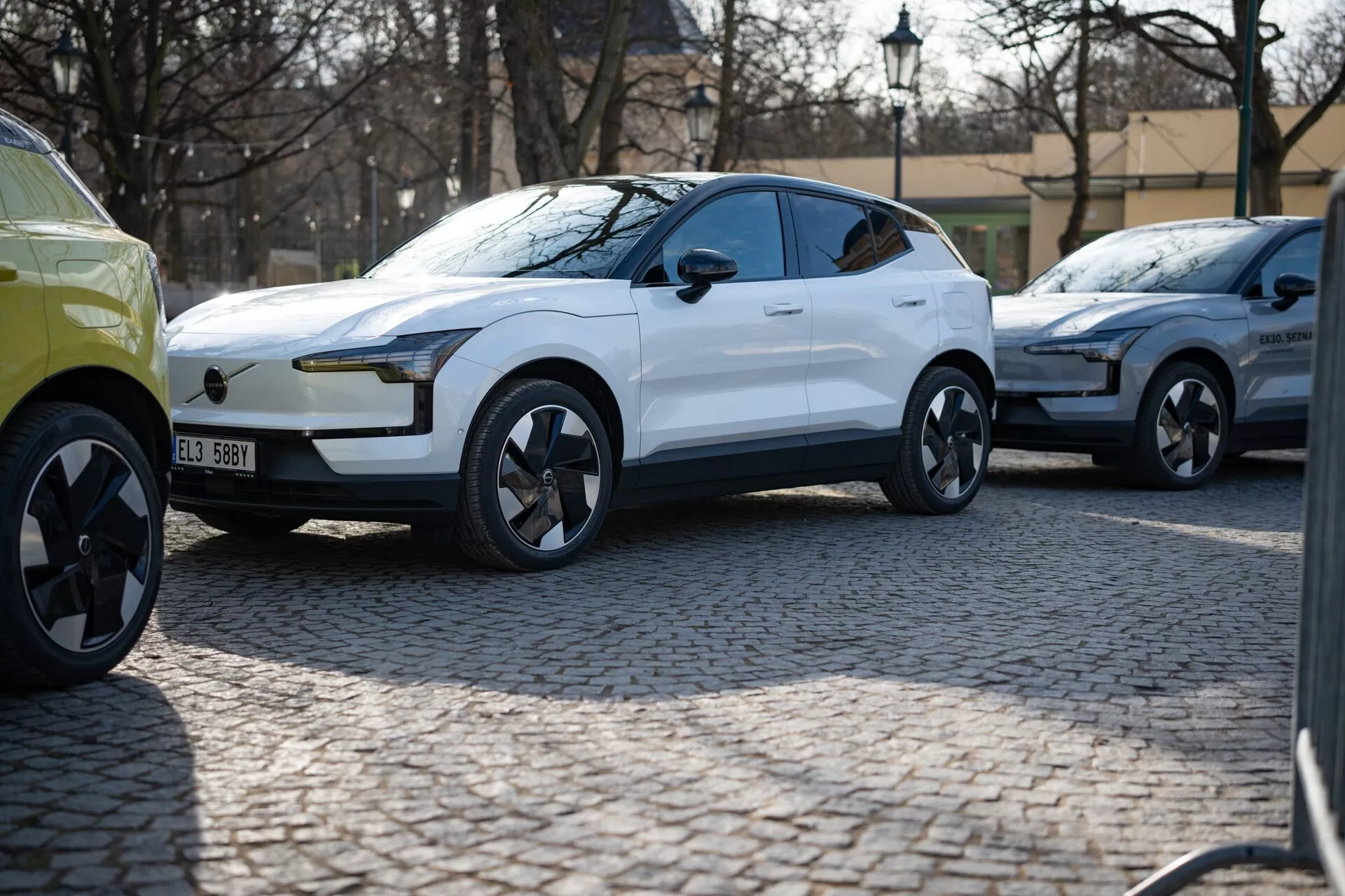 SUV crossover moderno bianco 2024 in vista tre quarti parcheggiato su una strada acciottolata, con vernice lucida, luci diurne a LED, maniglie delle porte a filo e cerchi in lega dal design dinamico che suggeriscono lusso e prestazioni, probabilmente un veicolo elettrico.