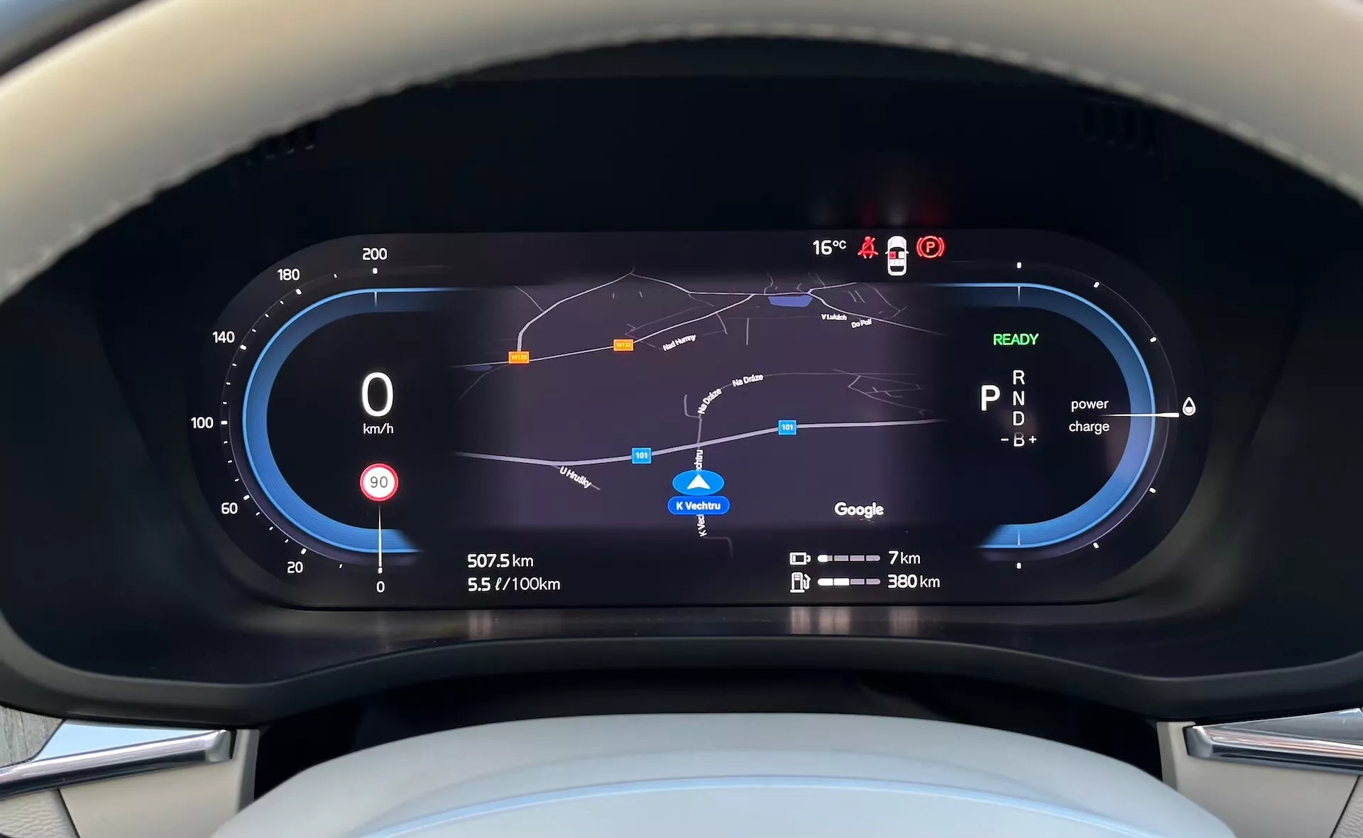 Vista del cruscotto digitale della Volvo XC60 Recharge Plug-In Hybrid 2021 dalla prospettiva del conducente, caratterizzata da tachimetro, indicatore di efficienza del carburante, utilizzo della potenza, mappa di navigazione e vari indicatori di guida