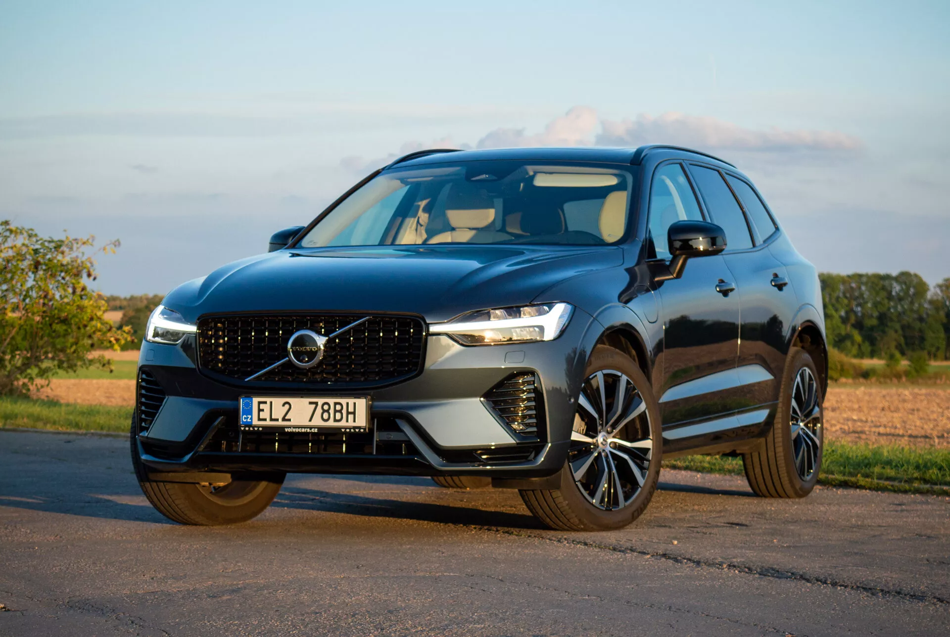 SUV Volvo XC60 Recharge Plug-In Hybrid 2021 parcheggiato sull'asfalto, che mostra il suo design elegante e le avanzate funzionalità tecnologiche da un basso angolo anteriore di tre quarti