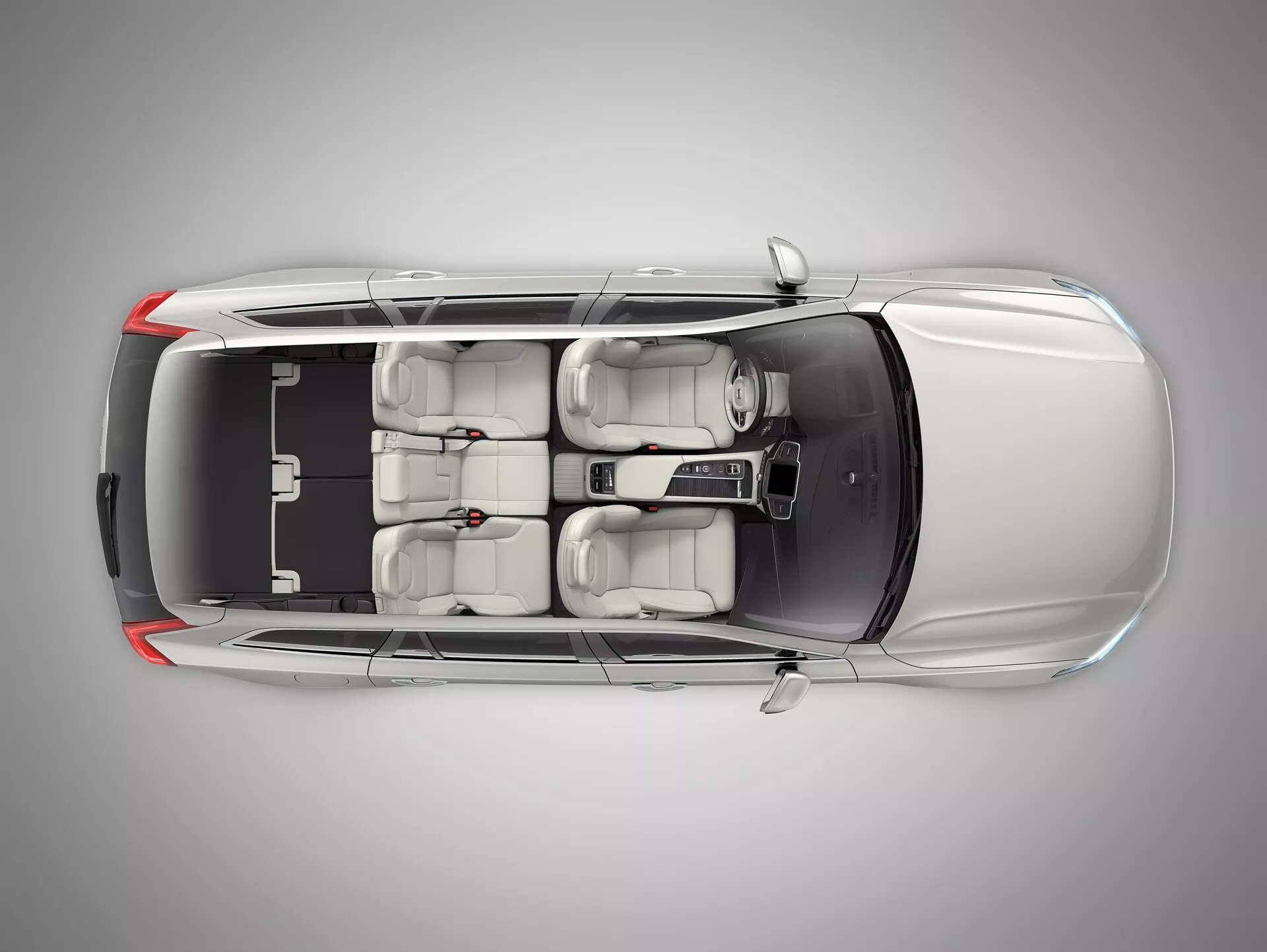 Vista dall'alto del Volvo XC90 2015 in metallo che mostra il tetto nero a contrasto, design aerodinamico, tetto apribile, due file di sedili con sedili anteriori regolabili avanzati, console centrale di controllo e finestrini oscurati, centrato in uno studio professionale.