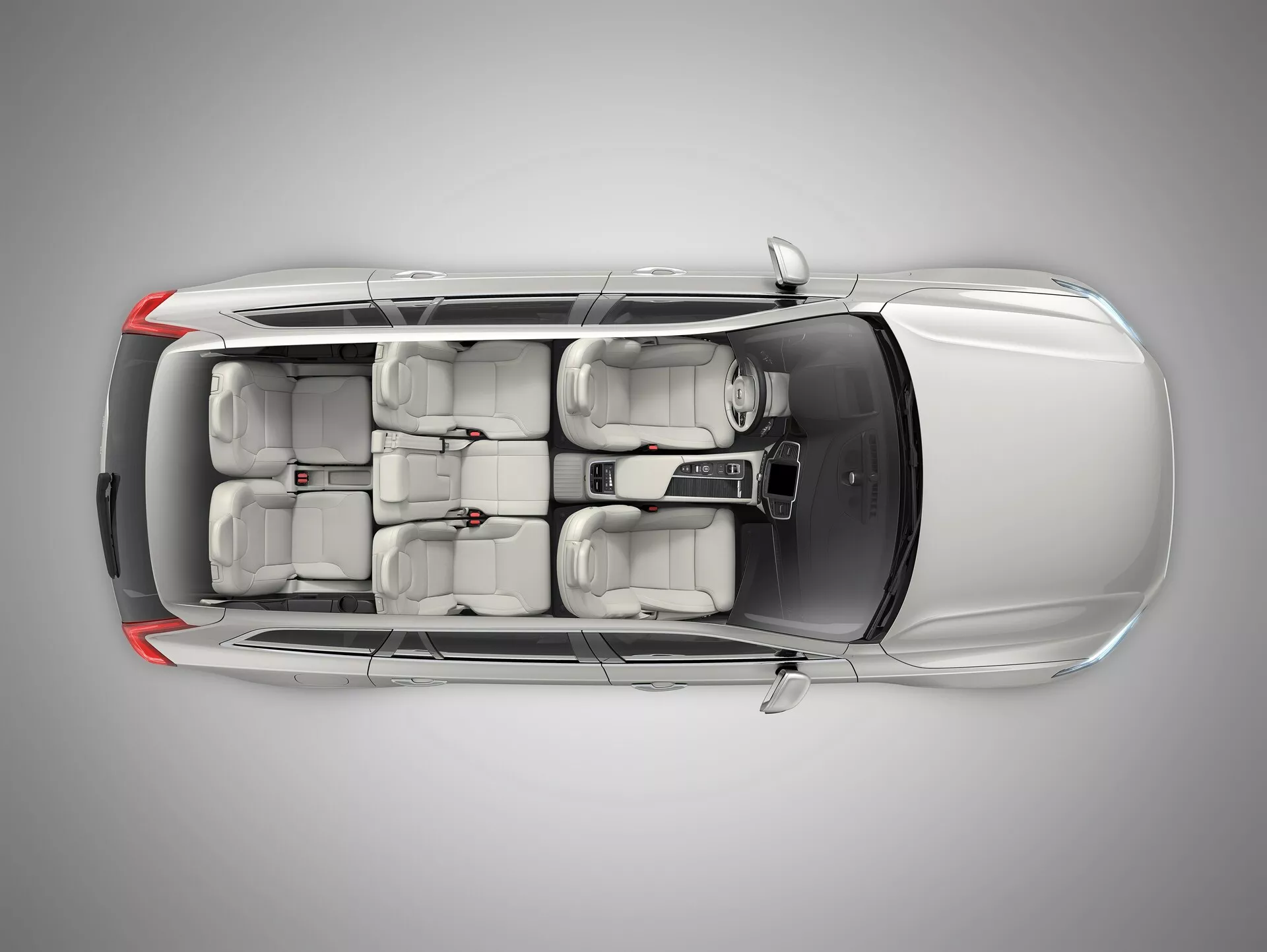 Vista dall'alto del Volvo XC90 2015 (2ª generazione), che mostra il tetto con pannello del tetto apribile o moonroof, quattro porte con maniglie a filo e configurazione dei sedili a tre file per sette passeggeri, indicando design moderno e guida a sinistra.