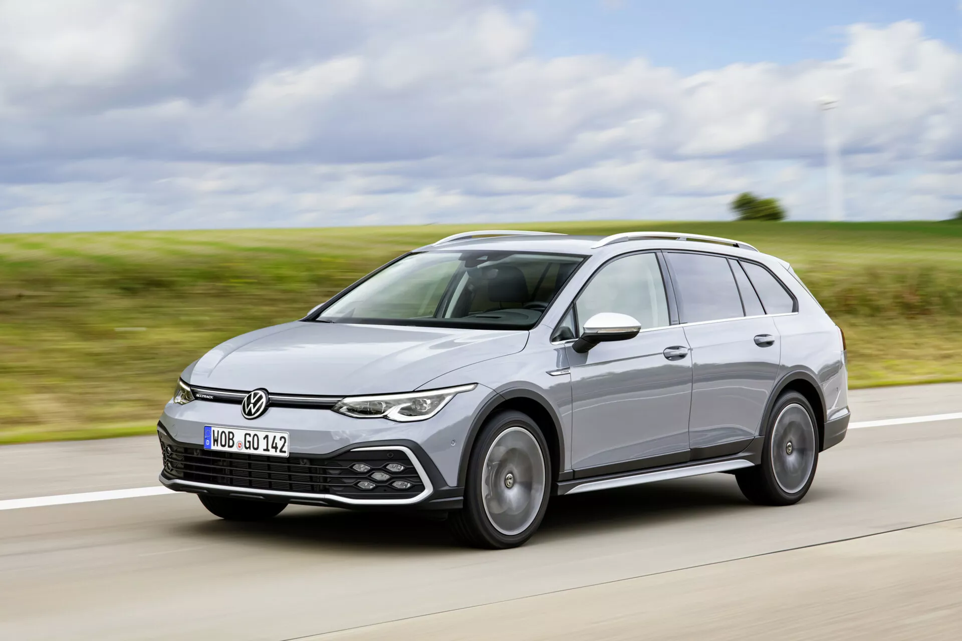 Volkswagen Golf Alltrack 2017 in movimento su un'autostrada, mostrando il suo design moderno da station wagon, fari LED, sensori di assistenza al parcheggio e sistema di barre sul tetto da un angolo frontale di tre quarti.