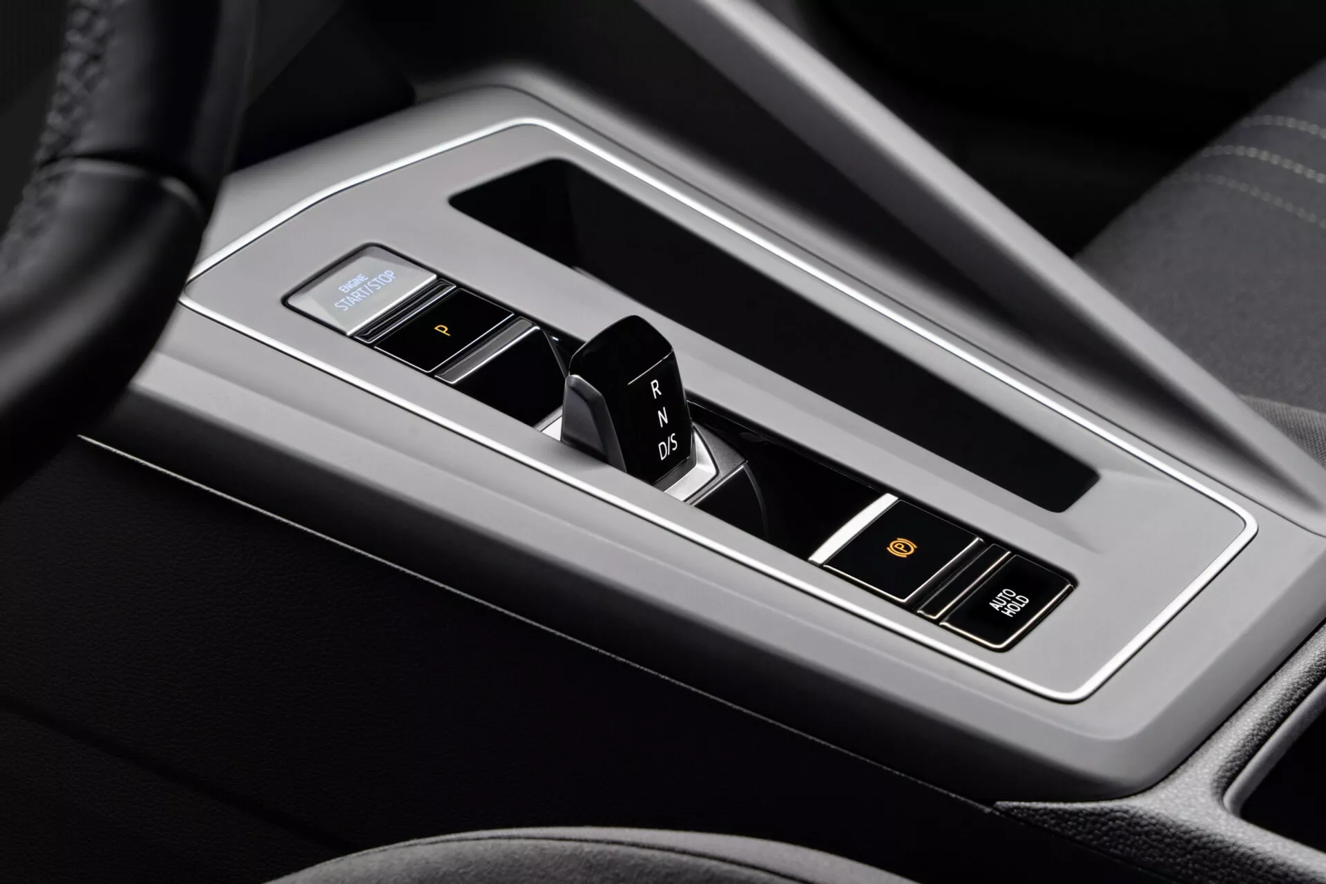 Vista ravvicinata della console centrale di VW Golf Alltrack 2017 che mostra il selettore di marcia elettronico in trasmissione automatica con layout P R N D, pulsante di avvio/arresto senza chiave e dettagli interni di lusso